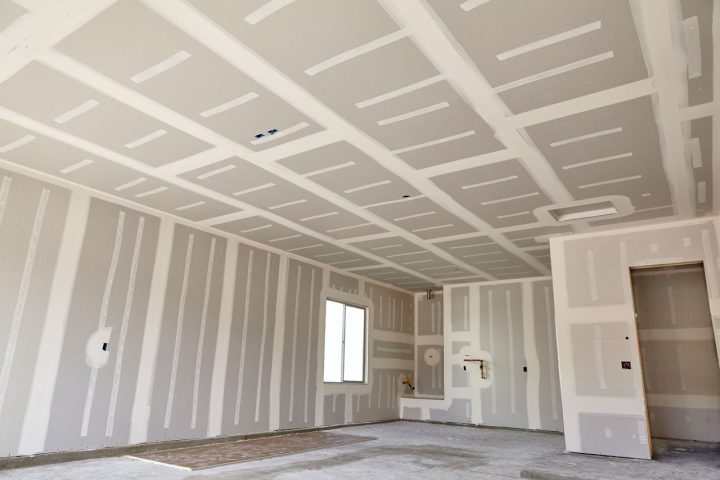An empty room undergoing drywall installation, highlighting the early stages of commercial space remodeling.