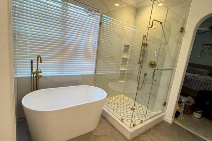 A modern bathroom featuring a freestanding bathtub, a walk-in shower with glass doors, and hexagonal floor tiles, creating a sophisticated and inviting space.